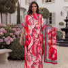 A woman models a pink and red tropical floral leopard print abaya scarf outdoors in a garden setting.