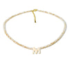 A delicate gold necklace featuring a mother of pearl chain with crystal accents and a letter M pendant.