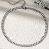 A silver multi-chain stainless steel anklet laid on a light surface.