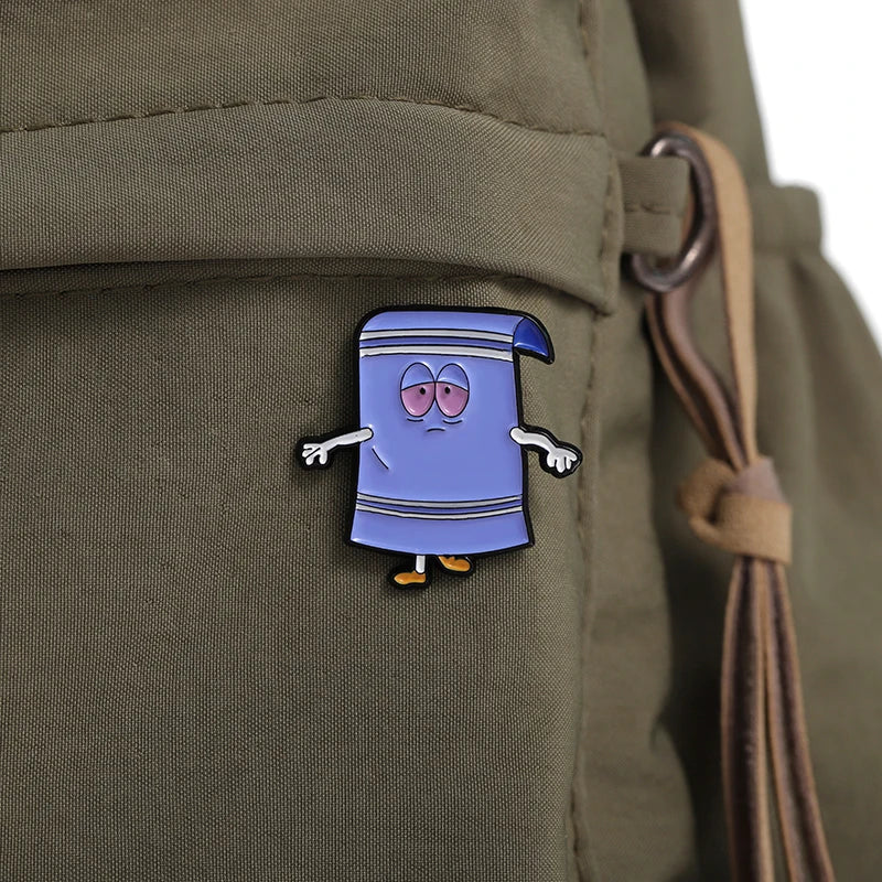 A purple cartoon enamel pin shaped like a wizard or character with a pointed hat and surprised expression, pinned on olive gr