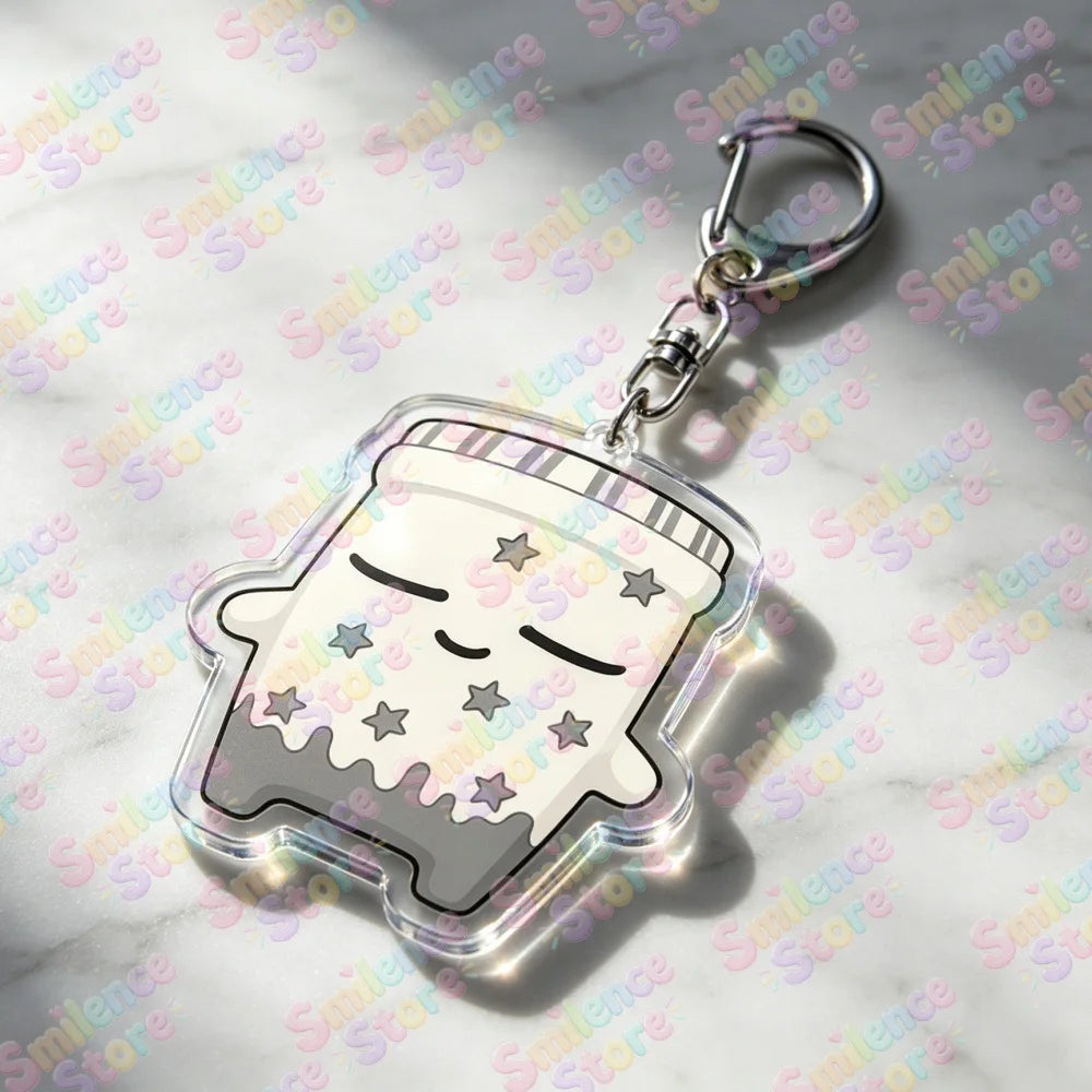 A clear acrylic keychain featuring a cute, smiling face design with stars and a striped pattern.