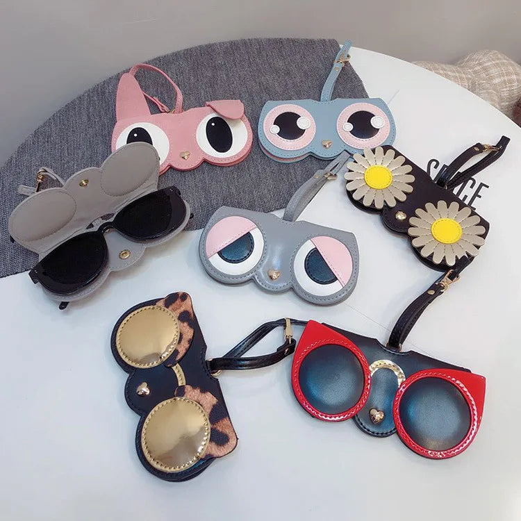 A collection of colorful, decorative eyewear storage pouches and sunglasses displayed on a white surface.