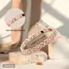 A close-up of a sparkling geometric energy bracelet made of light pink beads and silver metal, displayed on a natural stone.