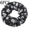 Un set de seis moños de terciopelo con estampado floral en blanco y negro para el cabello.