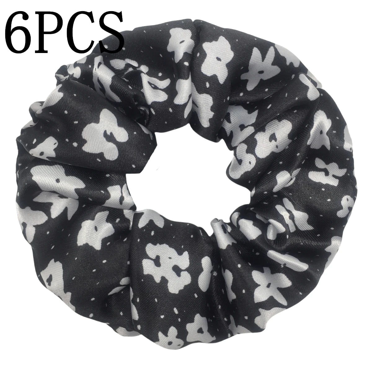 Un set de seis moños de terciopelo con estampado floral en blanco y negro para el cabello.