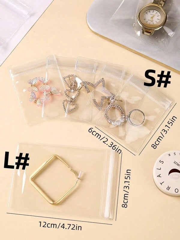 Pochettes de rangement pour bijoux auto-scellantes transparentes, montrant diverses pièces en argent et or.