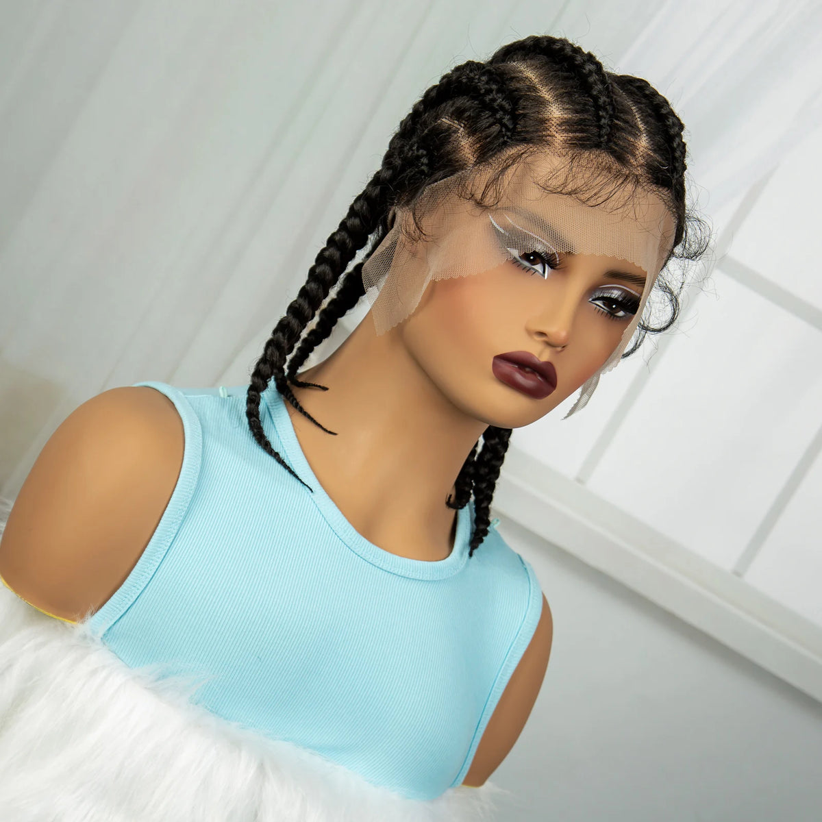Un mannequin porte un haut bleu clair et a les cheveux tressés avec des mèches transparentes encadrant le visage.