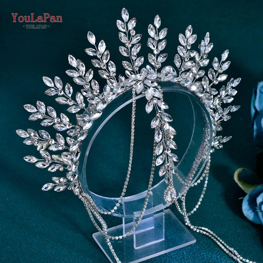 A sparkling rhinestone bridal crown headband displayed on a clear stand.