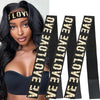 A woman models a black lace headband with gold lettering against a white background.