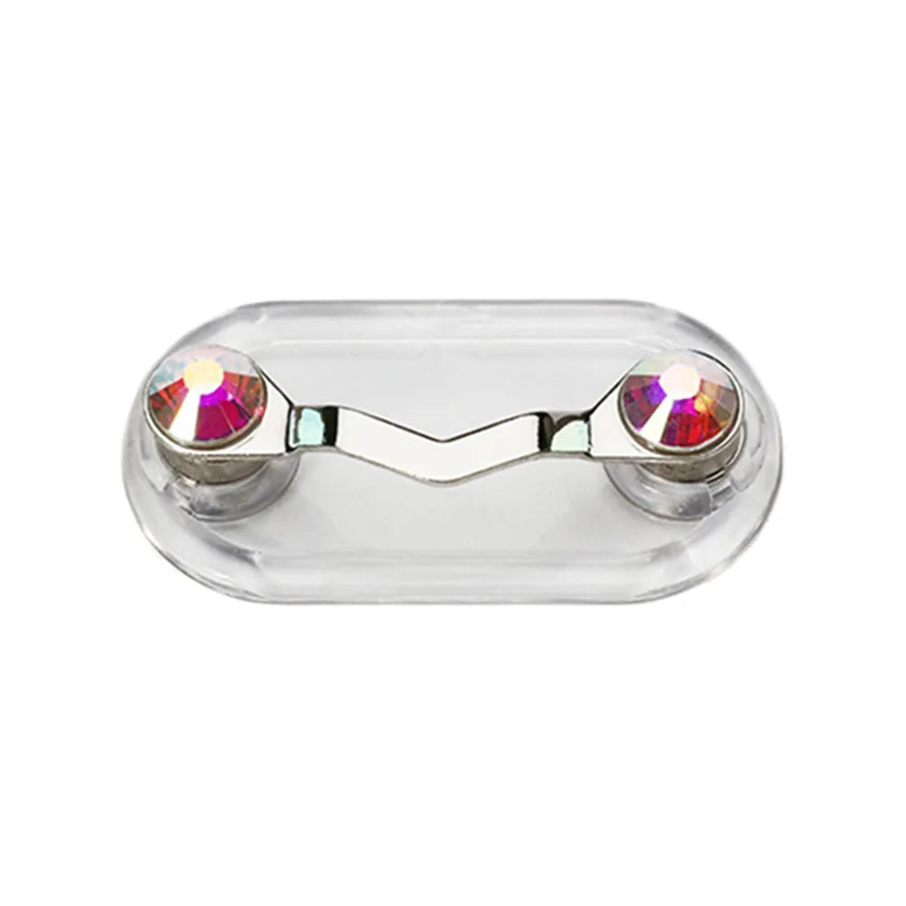 A clear plastic magnetic clip designed to hold eyeglasses, featuring two decorative gemstone accents.