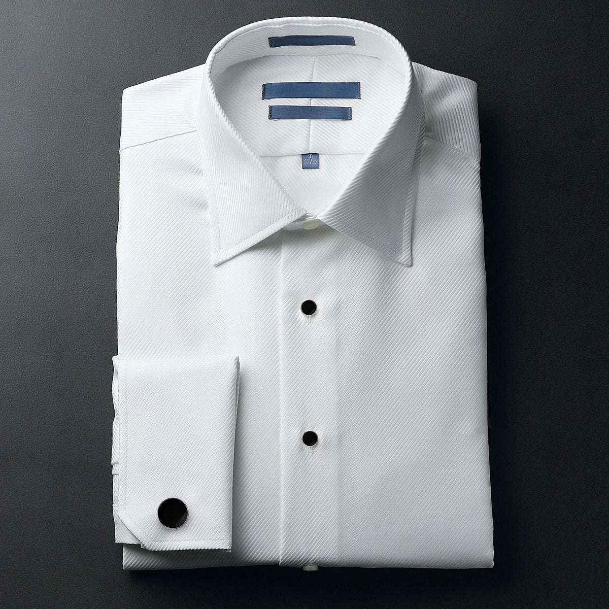 Chemise blanche avec accents bleus et manche repliée visible.