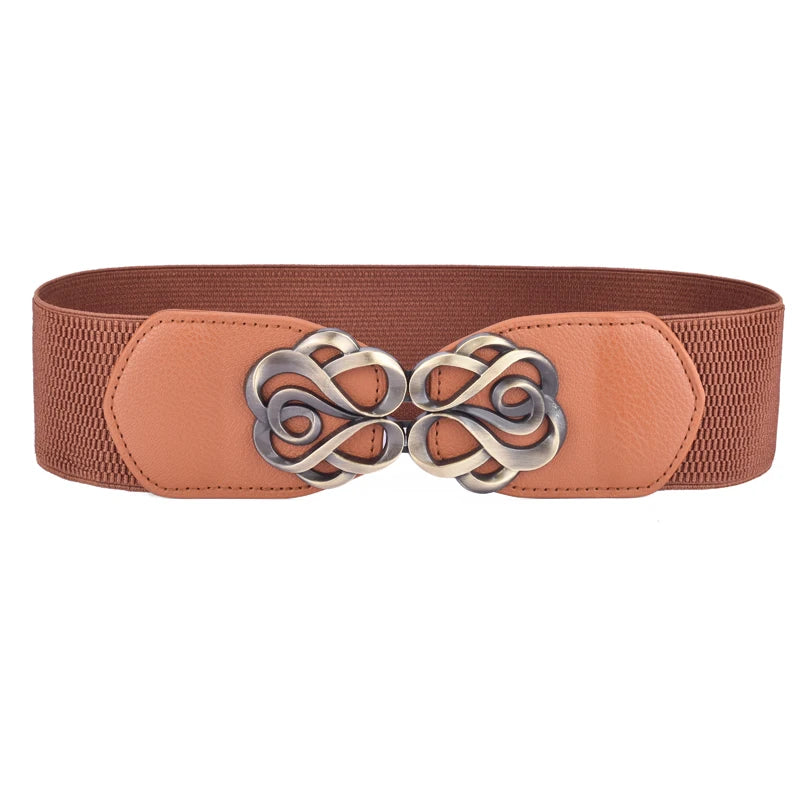 A vintage leather elastic belt in a dusty rose color with a decorative brass Celtic knot buckle.
