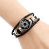 Black leather bracelet with silver accents featuring a circular sun design.