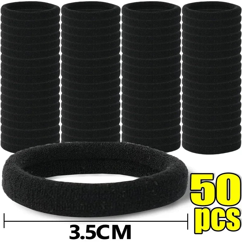 A set of five black elastic hair bands stacked vertically, with one band shown flat below.