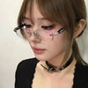 A close-up of a woman wearing vintage Y2K frameless glasses with decorative accents.