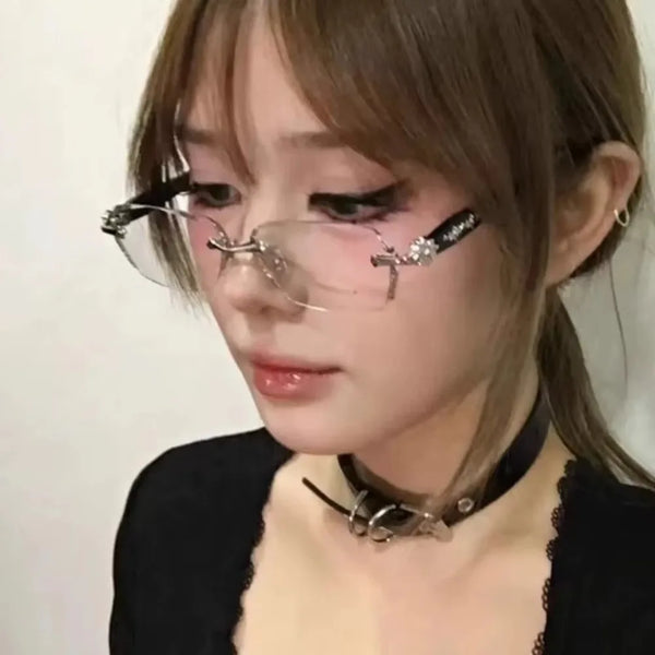A close-up of a woman wearing vintage Y2K frameless glasses with decorative accents.