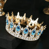 Couronne de diadème en strass de cristal or avec des gemmes bleues posée sur une surface sombre.