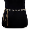 Gold and diamond heart chain body jewelry displayed on a black mannequin torso.