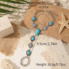 Silver beaded necklace and bracelet set featuring turquoise stones on a brown textured background