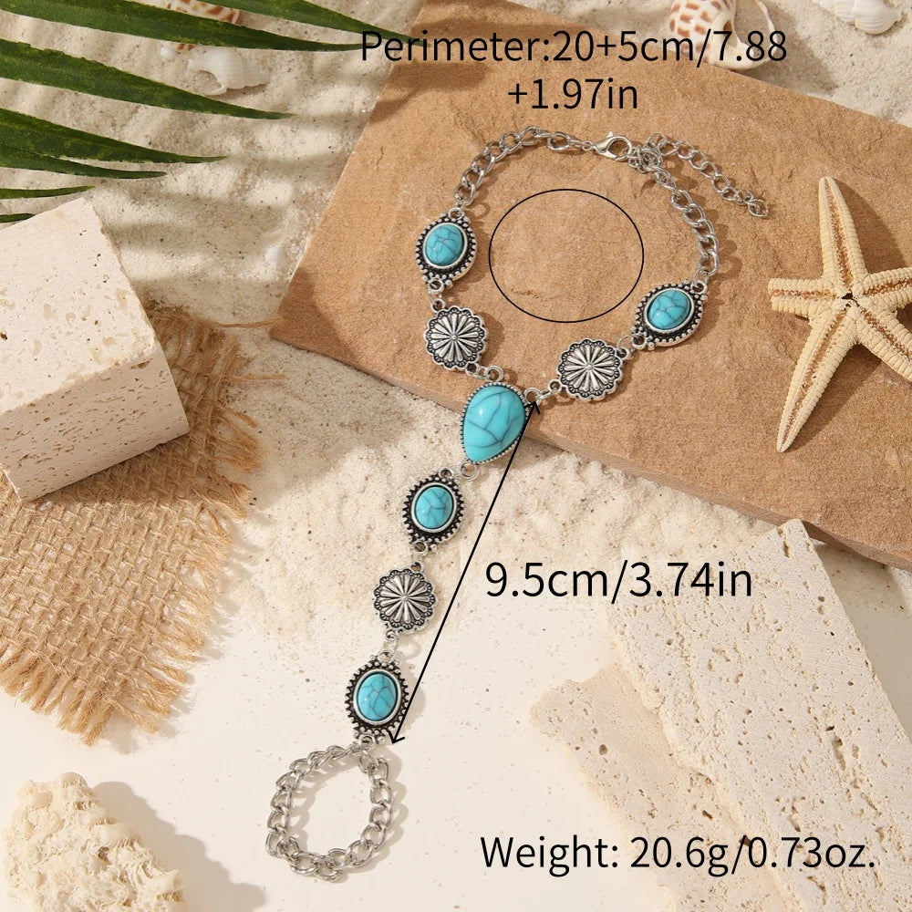 Silver beaded necklace and bracelet set featuring turquoise stones on a brown textured background