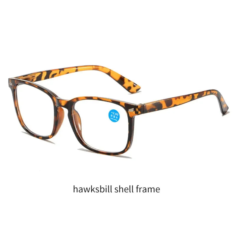 Un par de gafas de lectura de caparazón de tortuga con montura marrón oscura y lentes claras.