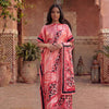 Une femme portant une caftan abaya imprimé léopard zèbre rose et noir dans une cour voûtée.