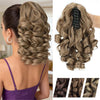 A woman shows off a long, textured blonde hair extension styled in an elaborate curly braid and wavy texture.
