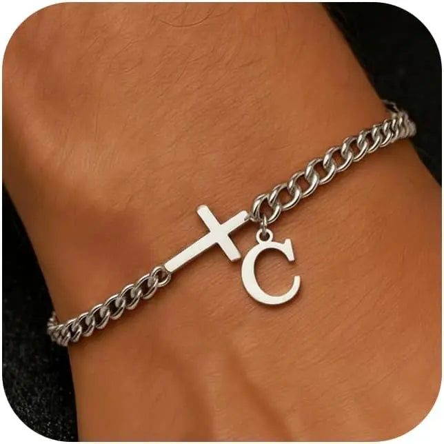 A close-up of a personalized stainless steel cross Cuban chain bracelet worn on a wrist.