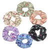 Un set de seis gomas de tela satinada con varios estampados florales, incluyendo verde salvia, rosa, lavanda y azul.