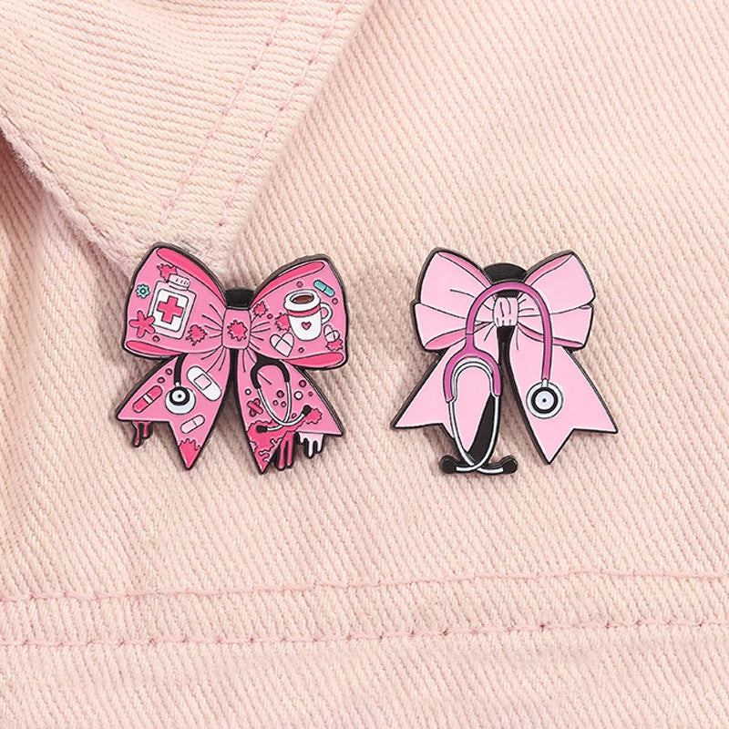 Pin de esmalte rosa con diseño de lazo, símbolos médicos y motivo de estetoscopio