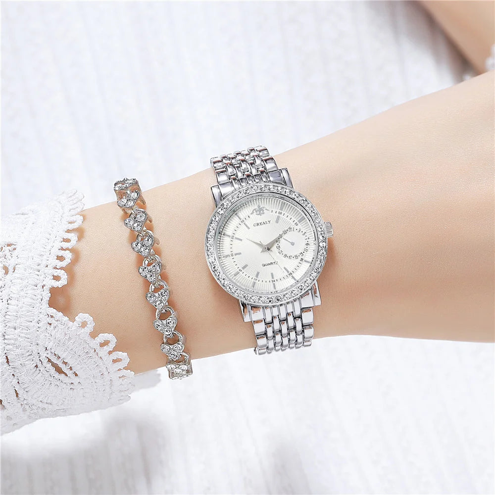 A close-up of an elegant two-tone crystal quartz wristwatch worn on a wrist, featuring a diamond-encrusted bracelet.