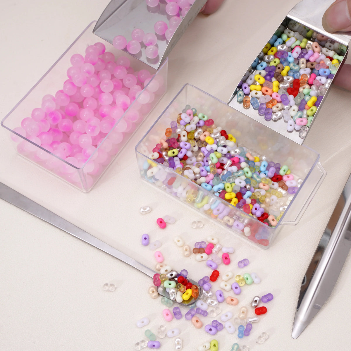 Stainless steel tools holding various colored beads for jewelry making
