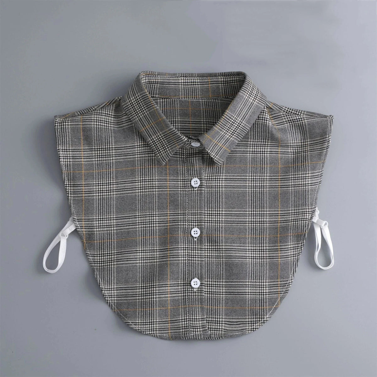 A grey plaid shirt with a collar and detachable necklines is displayed on a light gray background.