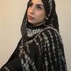 امرأة ترتدي حجاباً أسود مع وشاح من جلد التمساح باللونين الرمادي والأبيض.