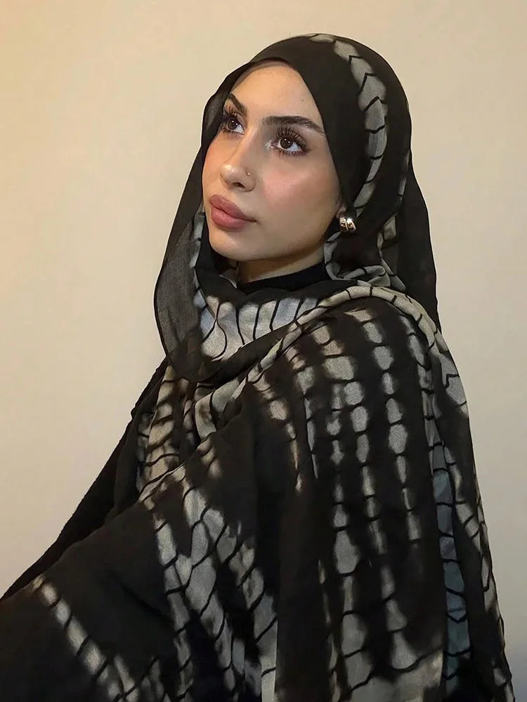 امرأة ترتدي حجاباً أسود مع وشاح من جلد التمساح باللونين الرمادي والأبيض.