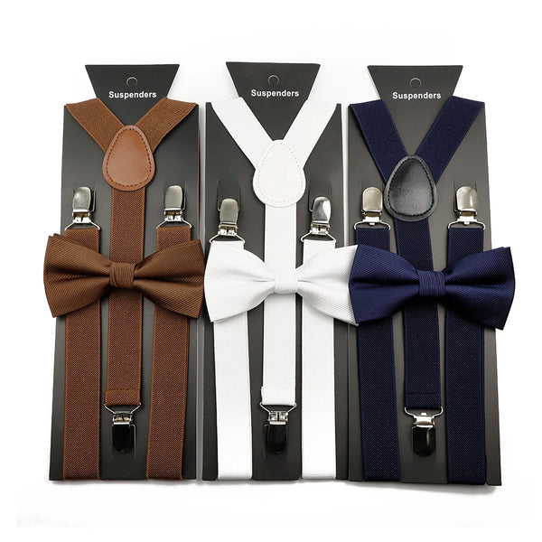 A set of adjustable polyester suspenders and bow ties in brown, white, and navy colors displayed in packaging.