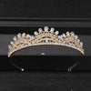 Gold-toned crystal rhinestone bridal tiara headpiece displayed on a dark surface.