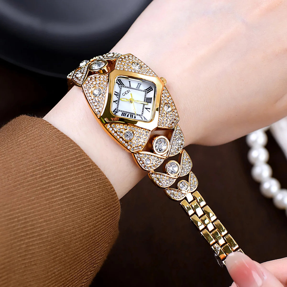 A close-up of a gold and diamond-inlaid quartz wristwatch worn on a wrist.