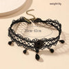 Black lace choker necklace with a gold chain and dark gemstone accents