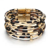 Pile de bracelets de poignet en cuir tube léopard bohèmes avec fermoirs dorés.