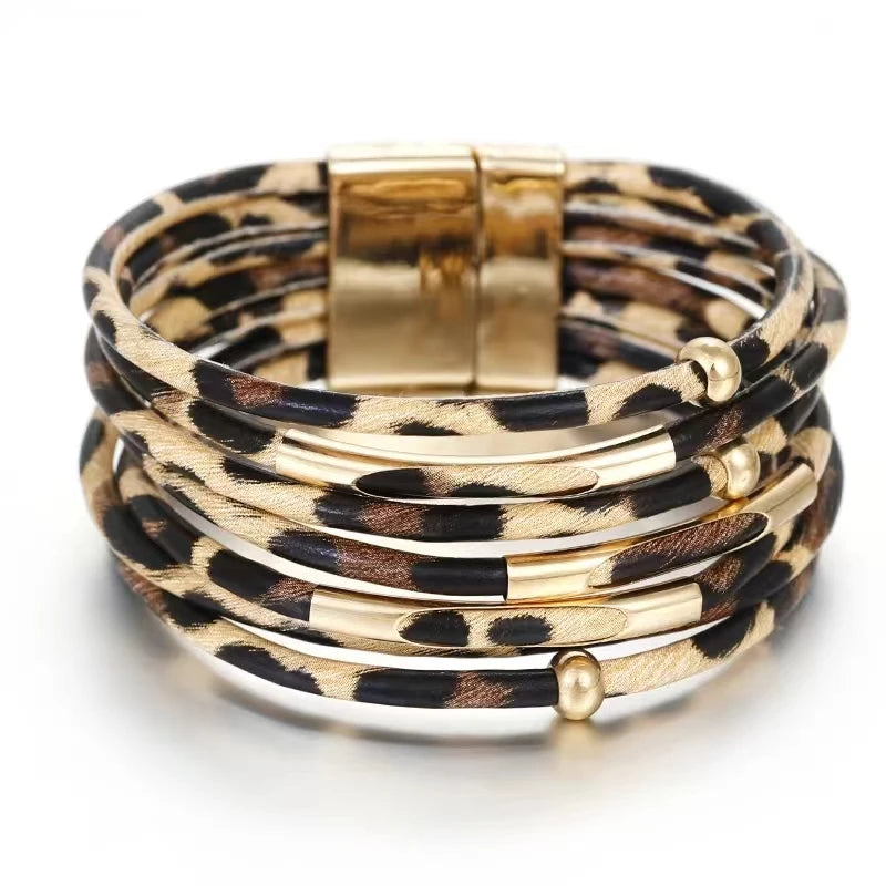 Pile de bracelets de poignet en cuir tube léopard bohèmes avec fermoirs dorés.