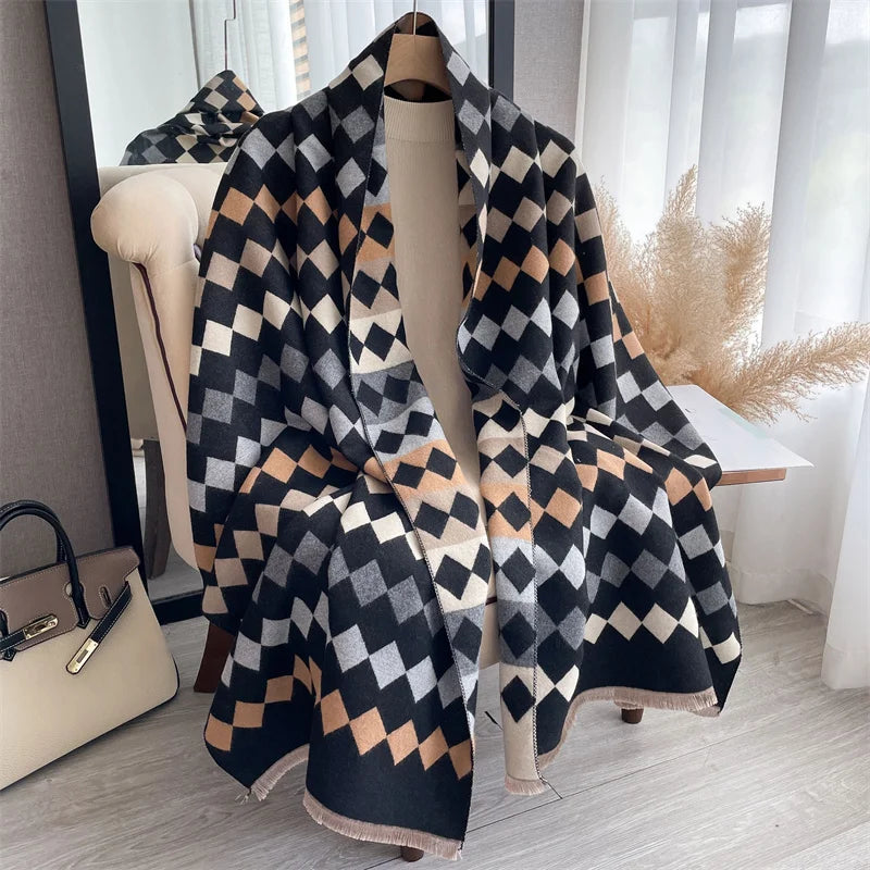A black and beige plaid cashmere feel scarf draped on a mannequin in a bright room.