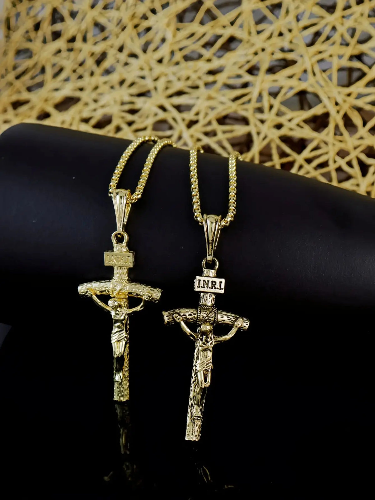 Goldplattiges Jesus-Kreuz-Anhänger-Halskette auf schwarzer Oberfläche mit gewebtem Goldhintergrund