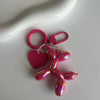 A pink jelly cartoon dog keychain with a heart-shaped charm and a pink loop.