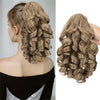A close-up of a long, textured blonde hair extension styled in an intricate curly braid and voluminous ponytail.