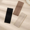Three solid color fashion headbands in black, taupe, and beige laid on a light background.