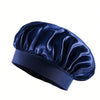 Bonnet pour cheveux en satin de soie bleu foncé plié et exposé sur fond blanc.