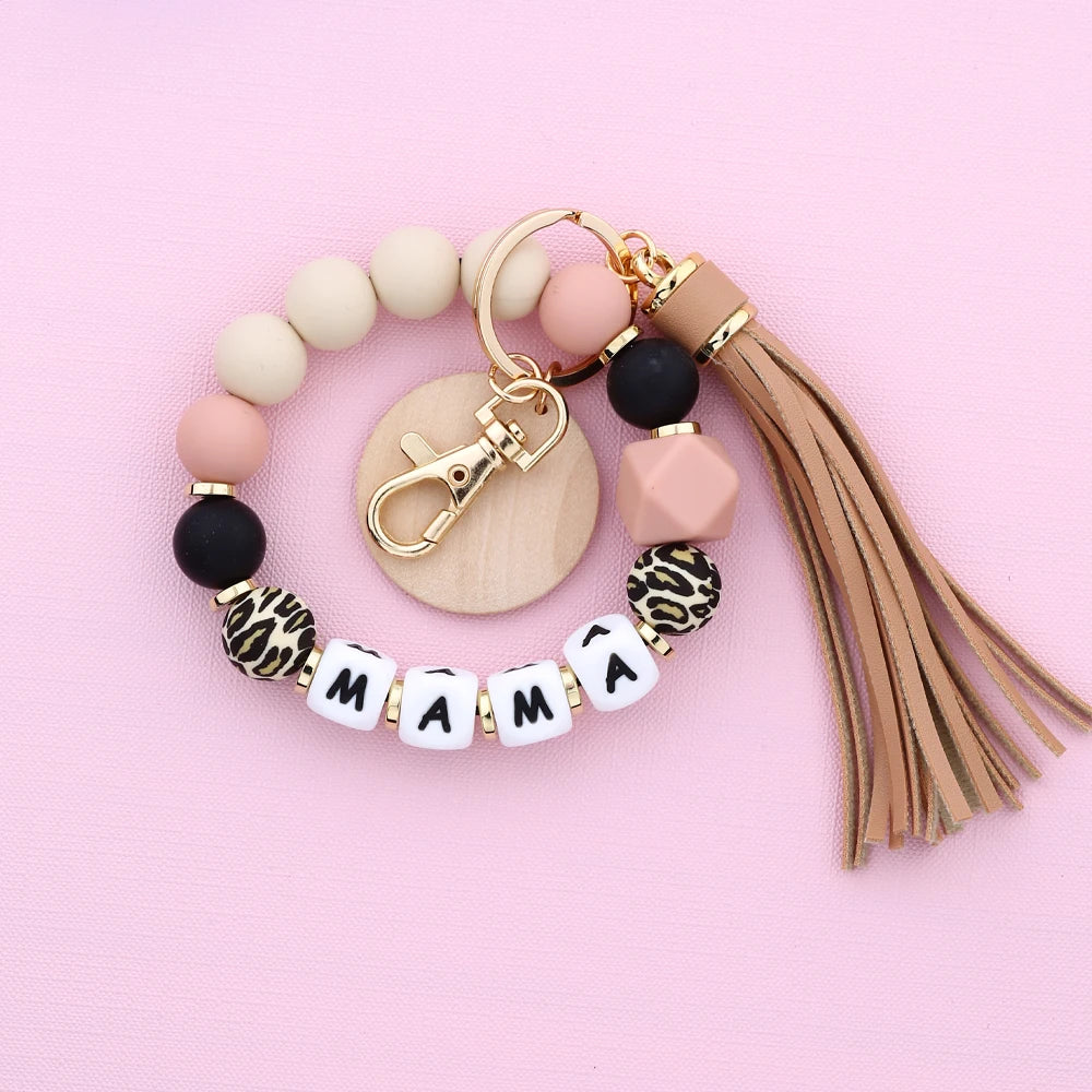 A gold-toned silicone bead necklace featuring leopard print and natural wood beads with a charm.