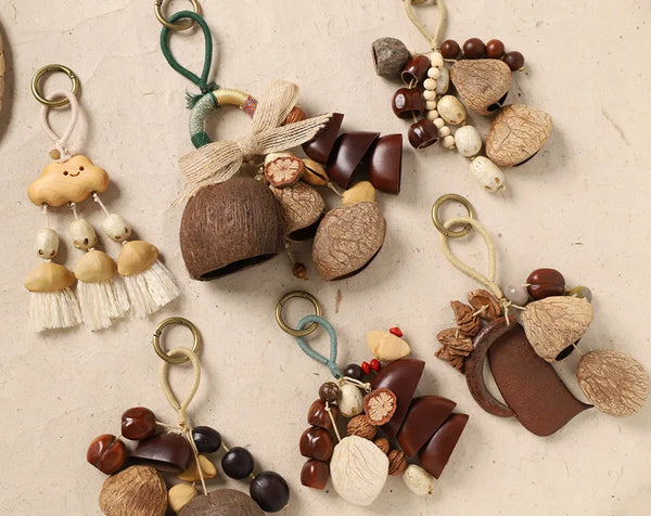A collection of hand-cranked fruit shell wind chimes and keychains in various natural earth tones and textures.