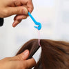 A hand is using a blue tool to remove an elastic from a strand of brown hair.